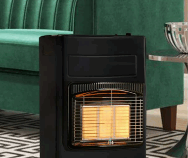 Black Totai gas heater placed in a living room with a green couch.