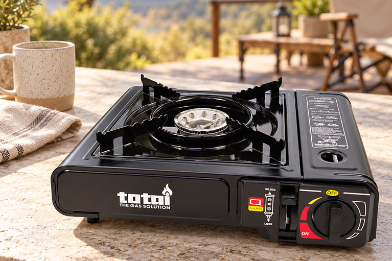 Totai portable single-burner gas stove on an outdoor table, ideal for camping, outdoor cooking and entertaining.